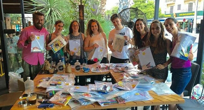 Volunteers with Ethelon pack activity kits for refugee children.
