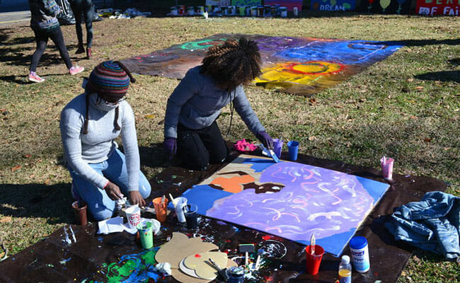 MLK Day 2018 volunteers painted boards with colorful pictures and inspiring messages, which would be hung on vacant buildings and homes in the English Avenue neighborhood. (Photo courtesy of Hands On Atlanta)