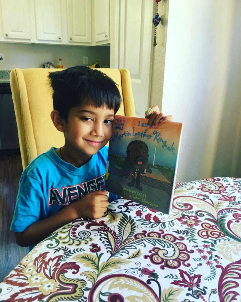 Mikhail holding "I am Martin Luther King, Jr." by Brad Meltzer, a book he read during a read-a-thon to raise funds for students in India./Courtesy Chanthara Laila