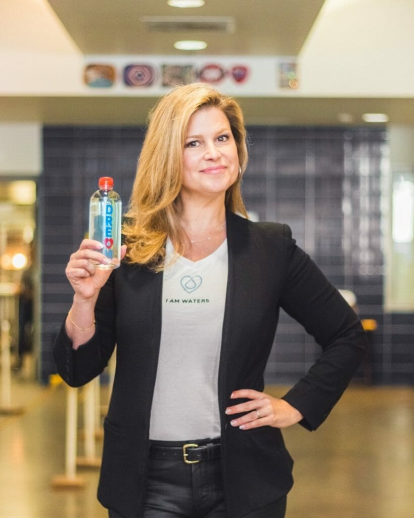 Elena Davis, holding a bottle of I Am Waters.