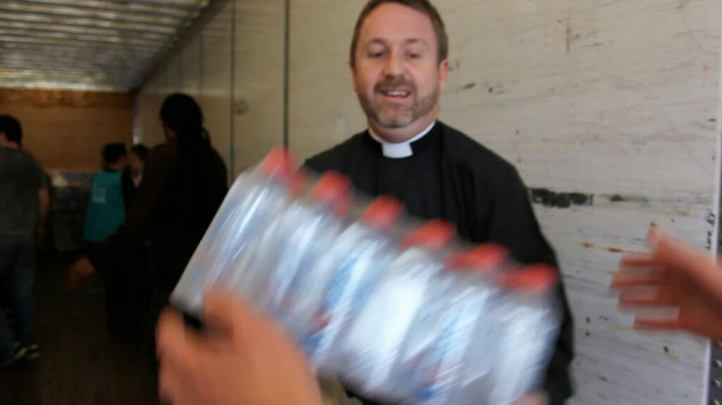 Volunteers unloading a truck of I Am Waters for distribution to victims of Hurricane Sandy.