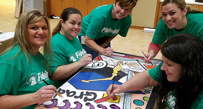 Fidelity volunteers participate in a school mural project on Fidelity Cares Day.