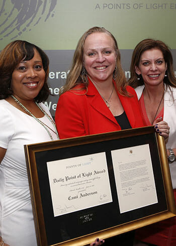 Cami Anderson, center, receives the Daily Point of Light Award at the generationOn luncheon. Presenting the award are Delores Morton, president of programs at Points of Light and executive director of generationOn, and Tracy Hoover, CEO at Points of Light.