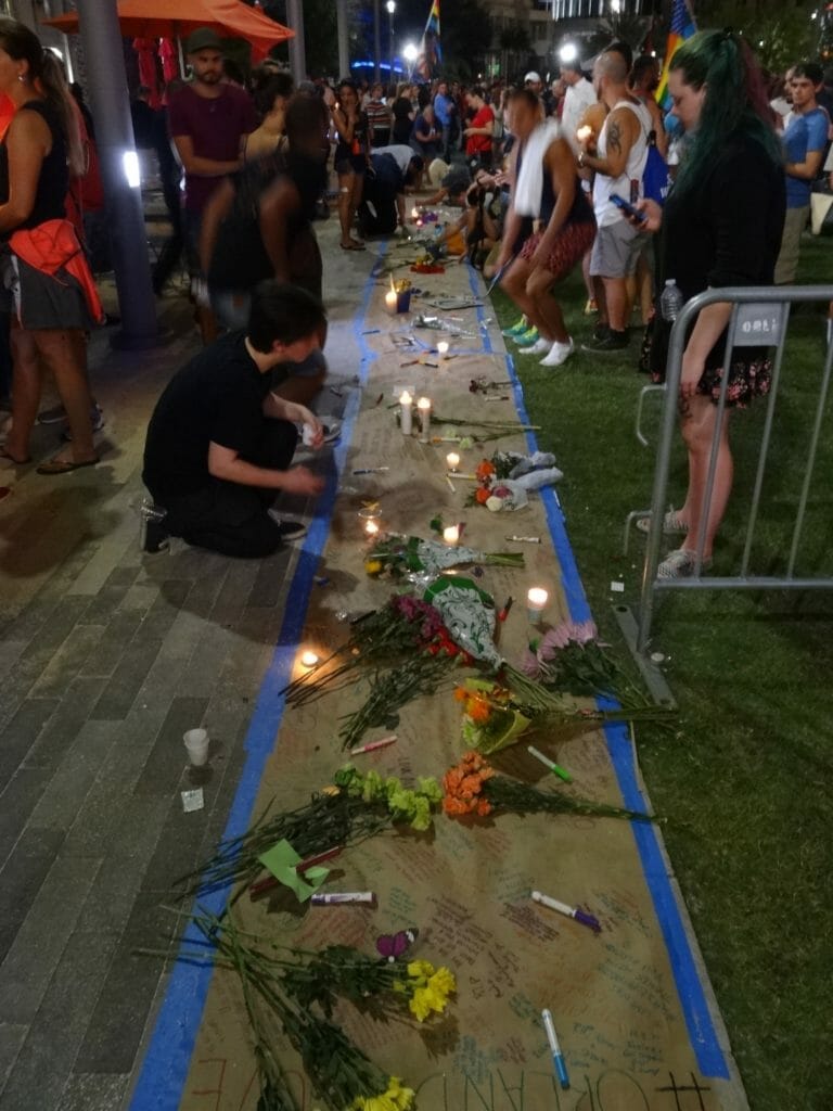 Volunteers signing a banner, leaving kind words for the families of the Pulse Nightclub shooting.