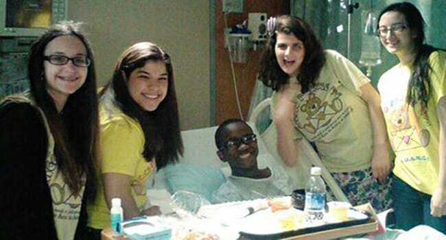 Amara Riccio created “Riccio Pick-Me-Ups” to share joy with others. Here she and fellow volunteers visit a patient in a children’s hospital.