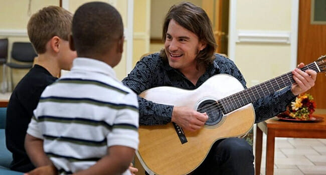 Country artist Jimmy Wayne sings to children in Mobile, Ala. The children were homeless and living with their mothers in the battered women's shelter.