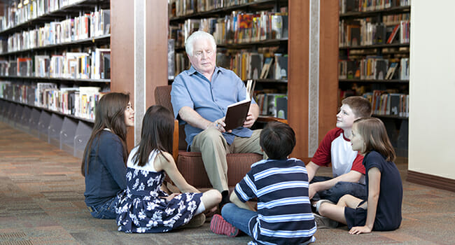 Senior citizen reads to children.