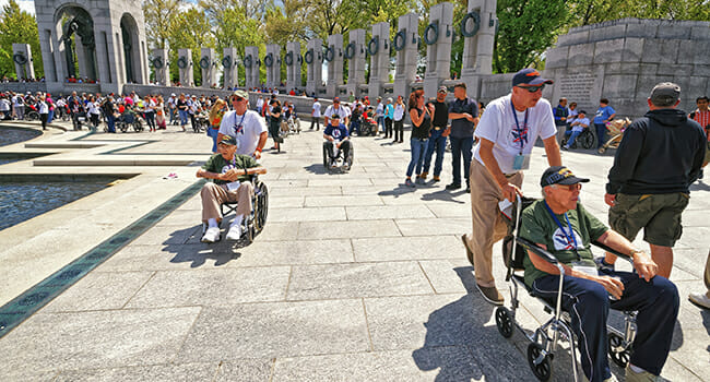 Veterans tour the WWII Memorial in Washington, D.C., with volunteers through Honor Flight, a nonprofit that gives veterans a free trip to visit monuments that honor their service. 