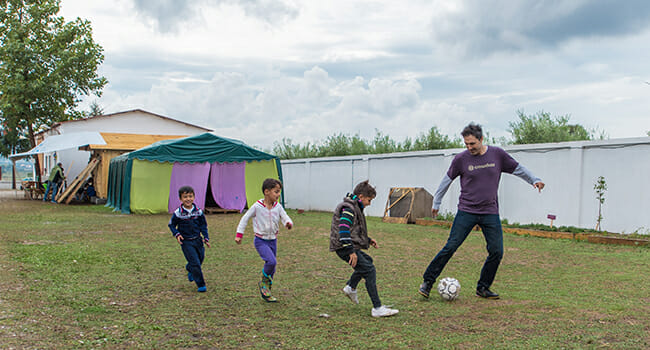 Ethan Zohn plays soccer with a group of refugee boys. In addition to a school and communal kitchen, the EKO Project provides a welcoming place for children to play.