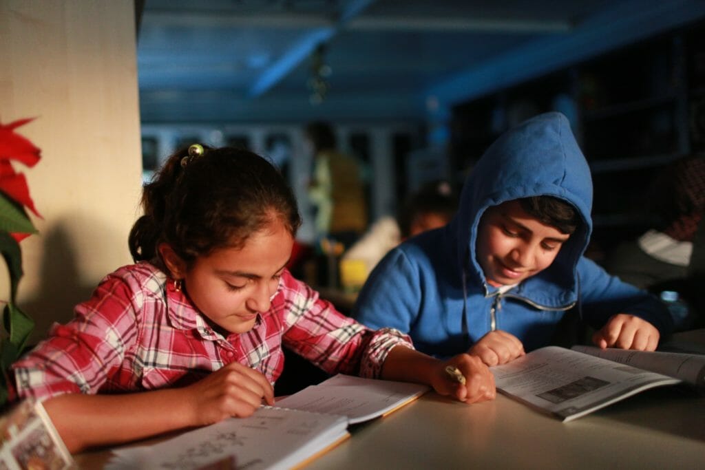 Students read books in a new library, funded by TentED, on the grounds of the Mar Elia Church in Erbil, Iraq. Photo: Anton Fric