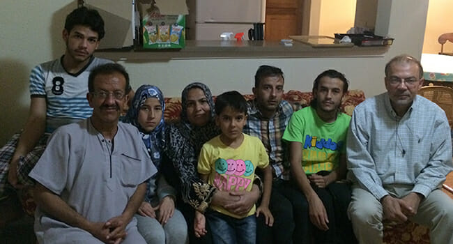 Sam Dooma (far right) with a newly arrived family of Syrian refugees.