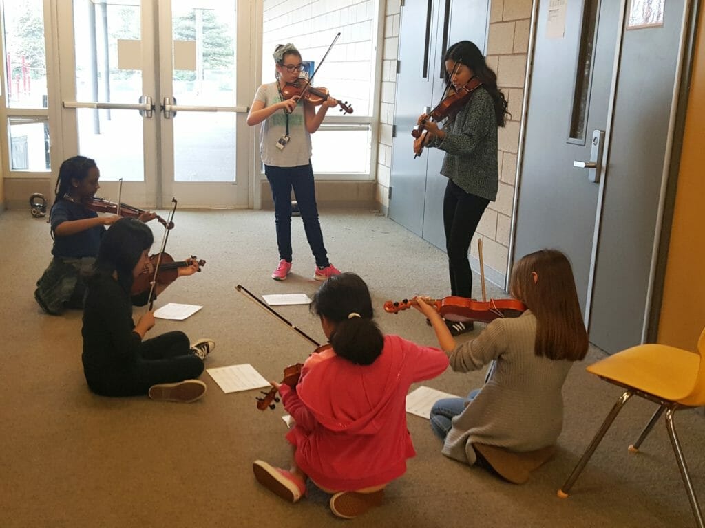 Cammie Lee teaching violin to students at Aloha-Huber Park K-8 School./Courtesy Isabelle Zheng