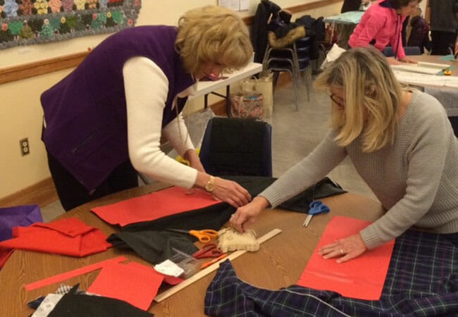 Volunteers cut and measure fabric at a moon bee in Schenectady, New York./Courtesy Ellie von Wellshem