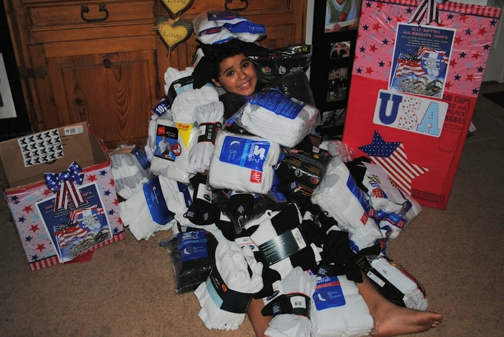 Evan Grace pictured with socks he collected during a sock drive for The Blue Star Mothers./Courtesy Merry Grace