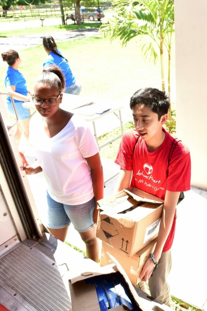 Jordan (right) helping unload food from truck for a grocery distribution in Kendall, Fla./Courtesy Miriam Wong