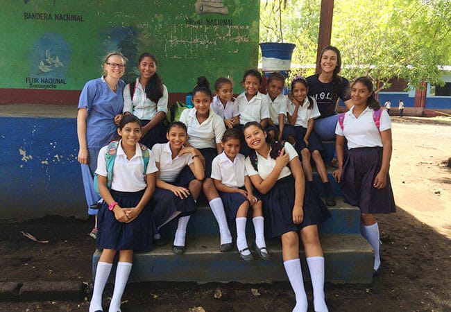 Sydney Lawrence, left, and another HOLA volunteer with students at Albert Barrios School, during a Public Health Day visit in 2016.