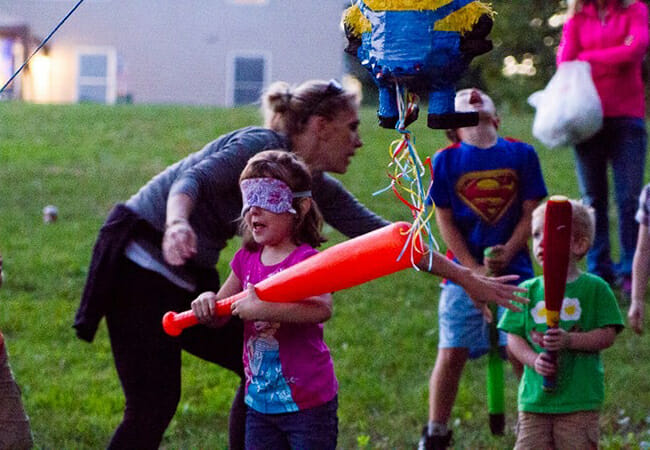 Joey helps kids with the piñata at the annual Warriors and Caregivers United BBQ, held each year in the Caswell family's home.