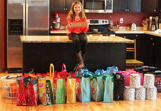 Maggie with a collection of laundry supplies and rolls of quarters after Make A Difference Day in 2015.