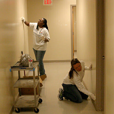 Volunteers covered nail holes and cleaned walls in preparation for painting.