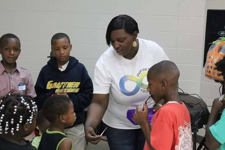 Ebony McLaughlin (center) at Infinity Youth Incorporated’s Back-to-School Bash, which equipped children and teens with school supplies./Courtesy Ebony McLaughlin 