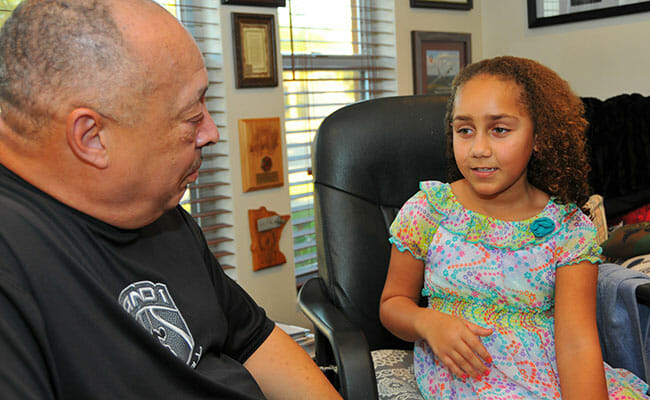 Nathan Thomas talks with his neighbor’s granddaughter, Alyssa, about the importance of school.  