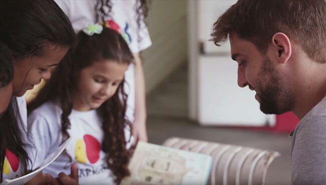 Through our network of affiliates in more than 200 cities across 35 countries, we are witnessing a dramatic awakening and proliferation of changemaking. Pictured here is André Cervi, co-founder of Points of Light's affiliate Atados, reading with children in Brazil.