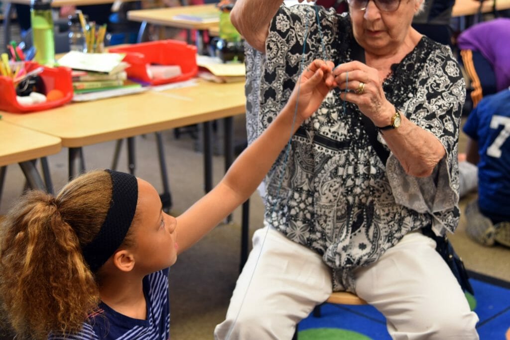 Pearl teaches a student from Daniel Bagley Elementary School how to create a quilt./Courtesy Pearl Conkle