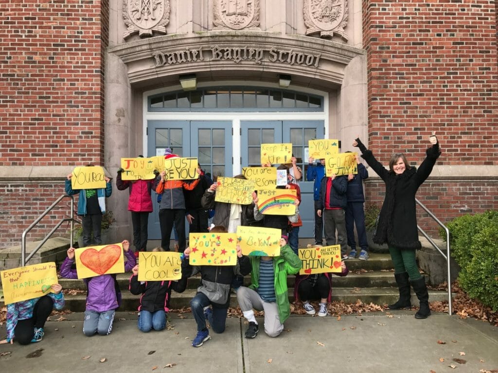 Students from Daniel Bagley Elementary School holding up Happiness Sprinkling Project signs./Courtesy Pearl Conkle