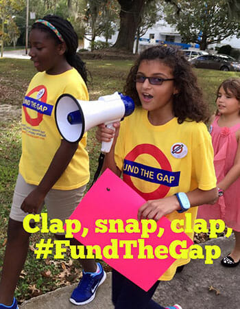 Paloma Rambana leads other children in a rally chant to raise awareness of her Fund the Gap campaign.