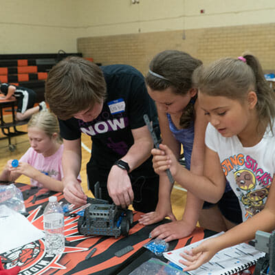 Gabriel Wimmer helps campers assemble a robot.