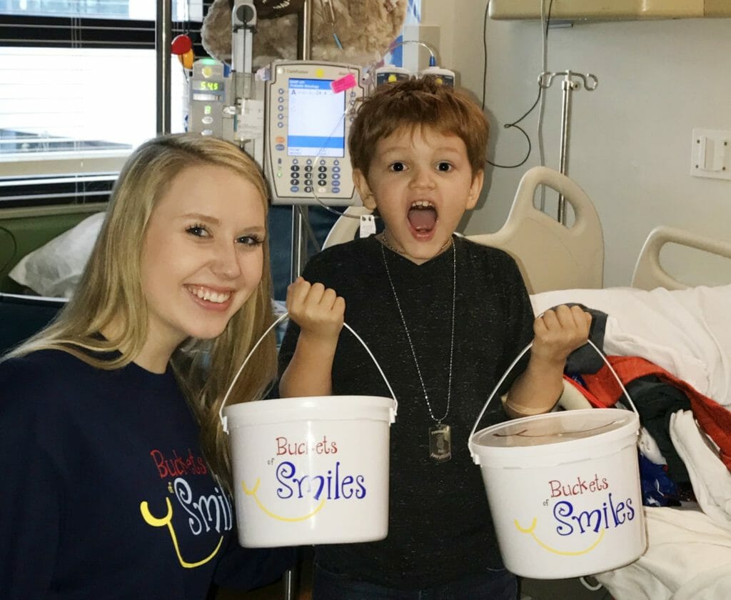 Ella Kate drops of a Bucket of Smiles container to a patient at The Studer Family Children's Hospital in Pensacola, Florida./Courtesy Ella Kate Nichols