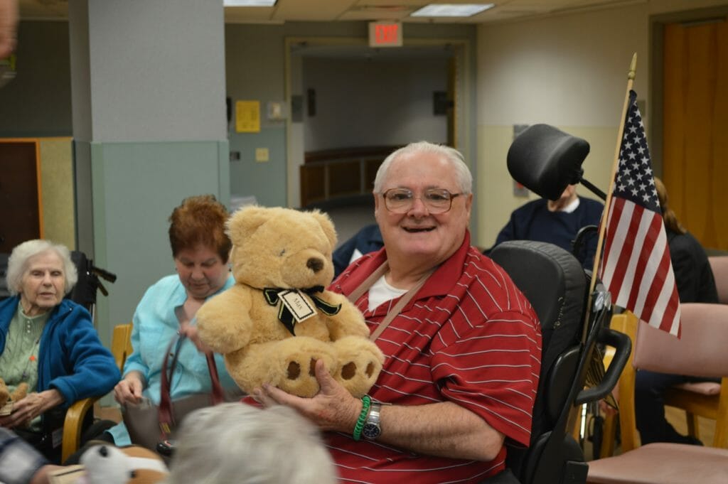 A nursing home resident recieves a refurbished teddy bear from The Stuffed Animal Rescue./Courtesy Katharine Trojak