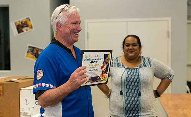 Claude Delorme accepts the Miami Rescue Mission “Group of the Month” award in November 2017, recognizing the service of his Marlins Ayudan team.