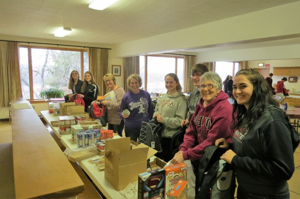 Kayla (far right) and volunteers for the C-FC Backpack Meal Program pack food kits for distribution to kids in need./Courtesy Kayla Kaczorowski