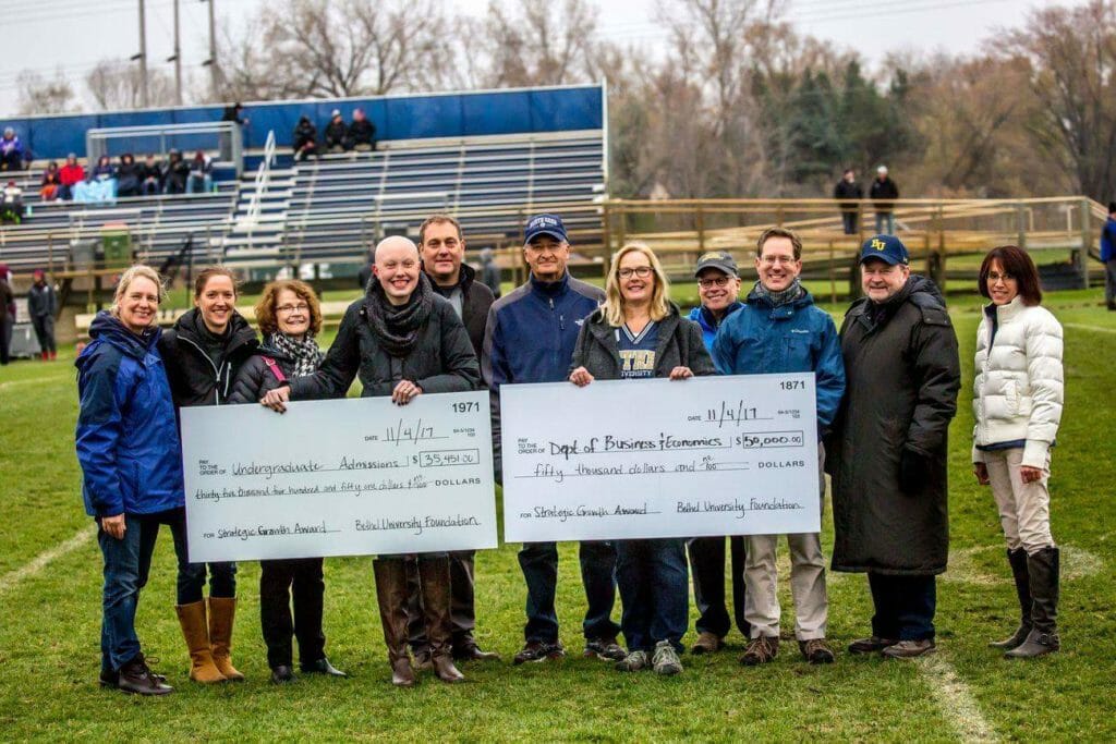Cedric Long (third from the right) with Bethel University Foundation Board of Governors at half-time during a local football game, presenting grant funds for two programs at Bethel University/courtesy Cedric Long