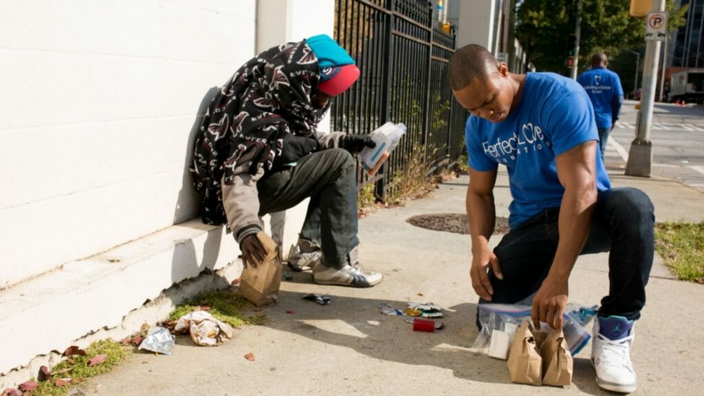 Taos Wynn (right) passes out food and hygiene kits to Atlanta’s homeless./Courtesy Taos Wynn 