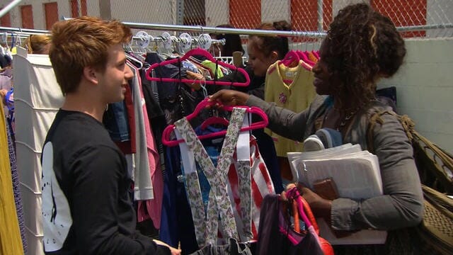 Dillon (left) helps a woman pick out some new upcycled clothes at a pop-up event in Venice Beach, California./Courtesy Dillon Eisman