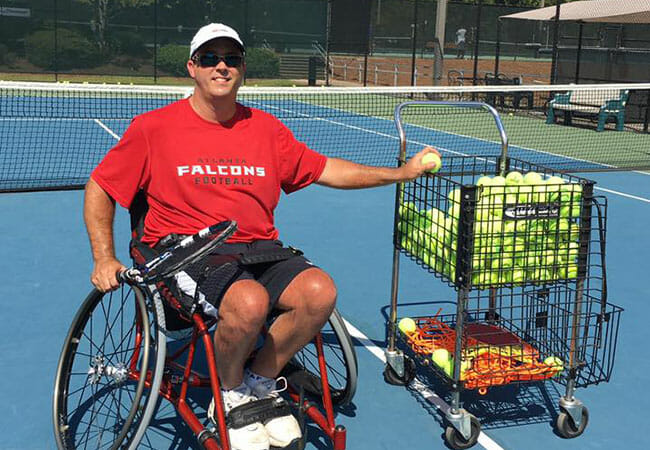 Rob Popelka prepares the tennis court for Wheelchair Tennis Atlanta clinic attendees.