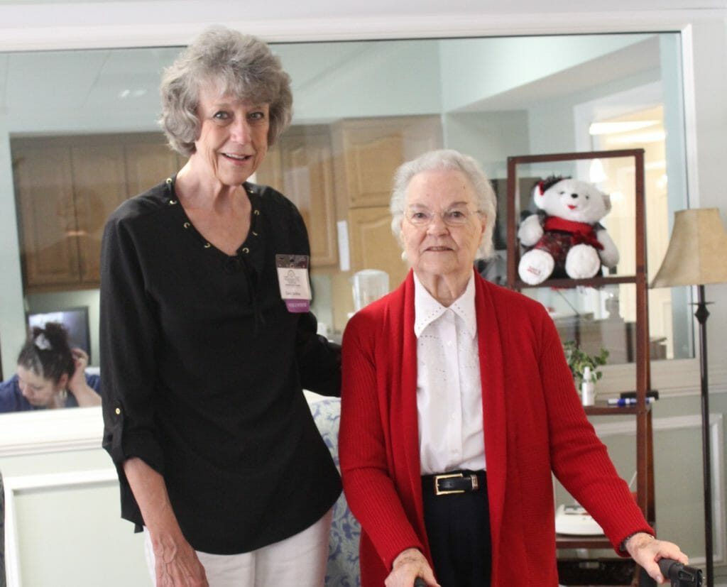 Carol Collins (left) strolling with a resident. Carol helps transport residents around the campus, and during Friday’s residents stroll./Courtesy Carol Collins