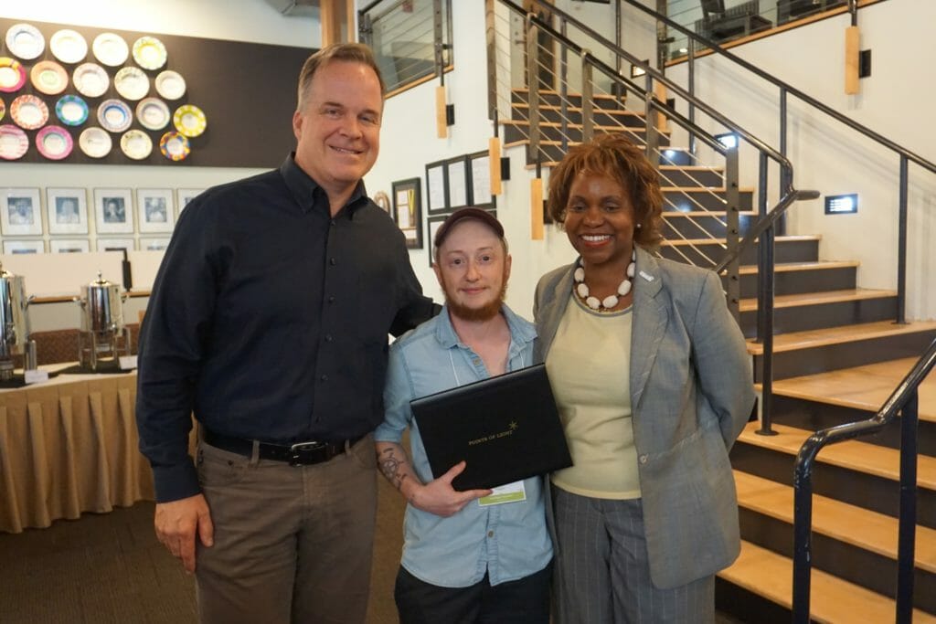 Tyler Hager accepting his Daily Point of Light Award at the Starbucks Service Fellows, powered by Points of Light program kickoff dinner in Seattle, Washington on Monday August 13th, 2018 with John Kelly, senior vice president of Global Responsibility, Community and Public Policy at Starbucks, and Points of Light CEO Natalye Paquin.