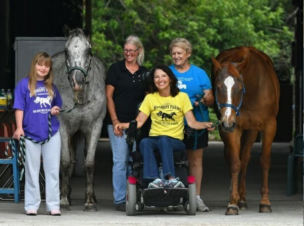 Pam Rogan alongside disabled riders Nicole and Michelle, and their therapy horses Shy Ann and Emily with volunteer coordinator Terri Carr (black shirt)./ Courtesy Pamela Rogan