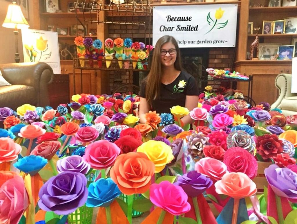 Sarah LoCurto sitting within the first field of paper flowers, just before Because Char Smiled initial delivery./ courtesy Sarah LoCurto