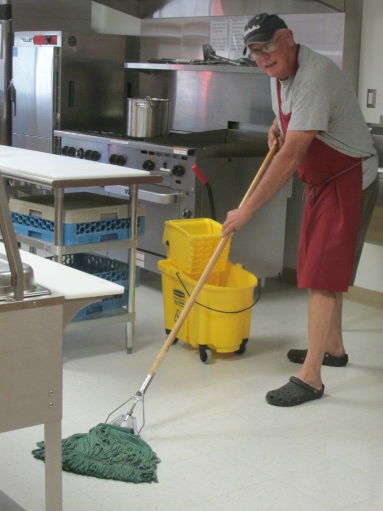 Lou cleaning up after serving a hot meal at the Community Center./ Courtesy Lou Woltering
