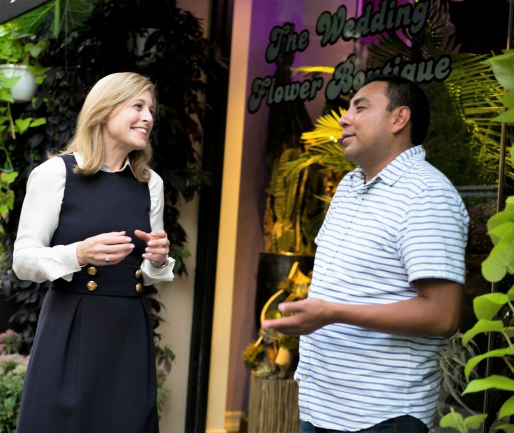 Jane Veron speaks with a flower shop owner as part of a “Buy Local” effort to stimulate foot traffic in local retail hubs./ Courtesy Jane Veron