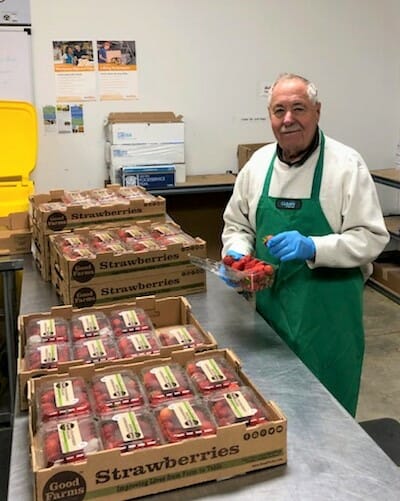 Bob Marshak at the Harvey Kornblum Jewish Food Pantry sorting through strawberries to pick out ones that have spoiled./Courtesy Bob Marshak