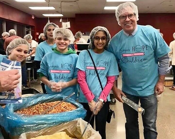 Members of Sanya Pirani’s Sanya’s Hope for Children team join Prior Lake (Minn.) Mayor Kirt Briggs in packing food for impoverished children in a Haitian village./ Courtesy Sanya Pirani