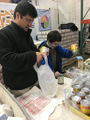 Sherin and Ben Elwy create food bags for distribution at the local Red Cross food bank. 