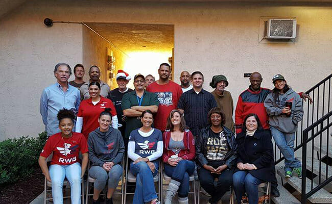 Marisa Saucedo (left, second row) and Team Red, White and Blue eagles host a Christmas party at a transitional home for veterans. 