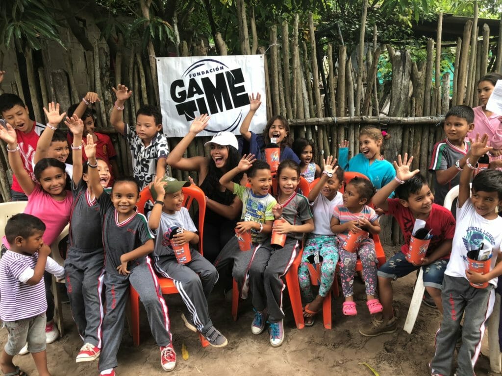 Baseball players ages 4 to 10 in Atlantico, Colombia receive Miami Marlins souvenir cups, along with toothbrushes as a symbol of health from Nicole Fernandez in 2018 as part of her Game Time Foundation charitable work./ Courtesy Nicole Fernandez