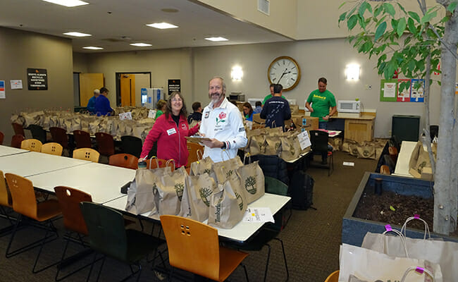 Claire Bloom and board member Keith Launchbury participate in a volunteer meal-packing event. 